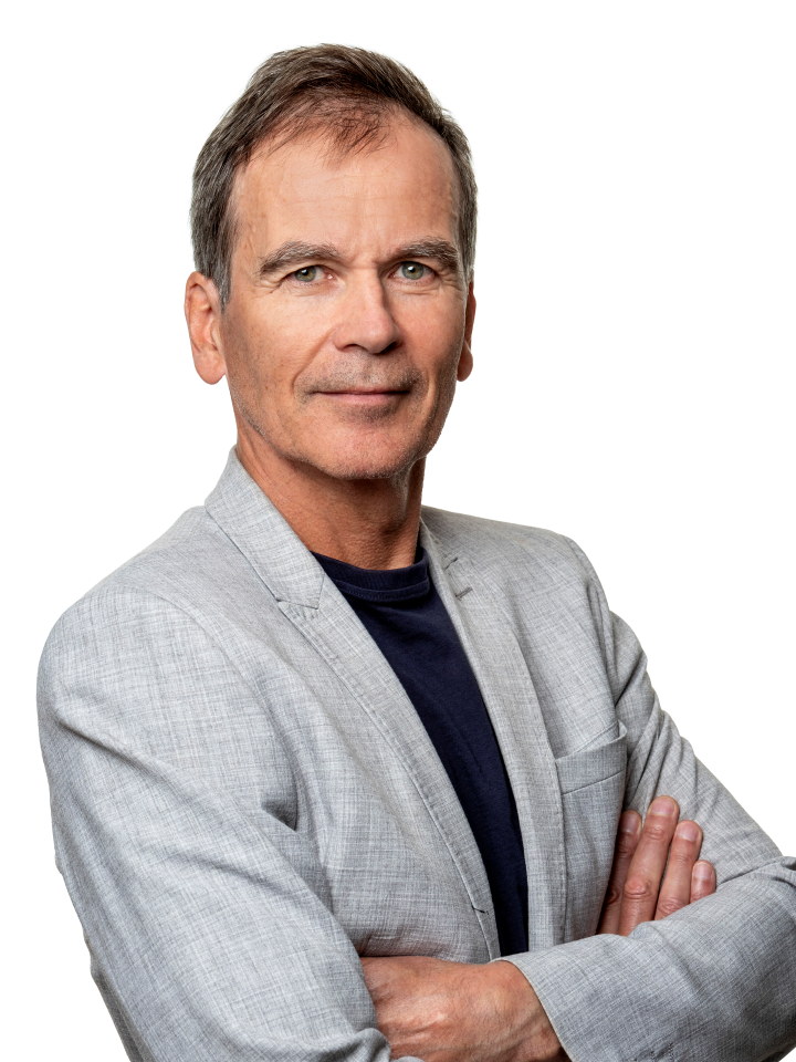 En smilende mann i grå dressjakke. Portrettfoto.